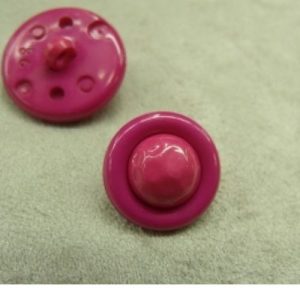 bouton acrylique composé sur fond fuschia