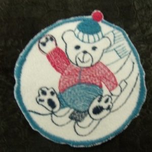 écusson thermocollant Motif NOUNOURS SUR LUGE bleu rose et noir sur fond blanc 6,5 cm