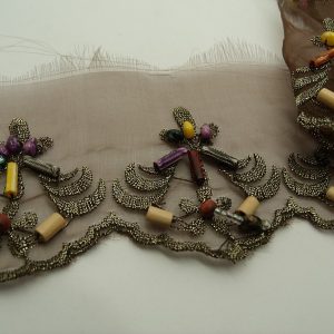 ruban brodé avec perles sur voile marron